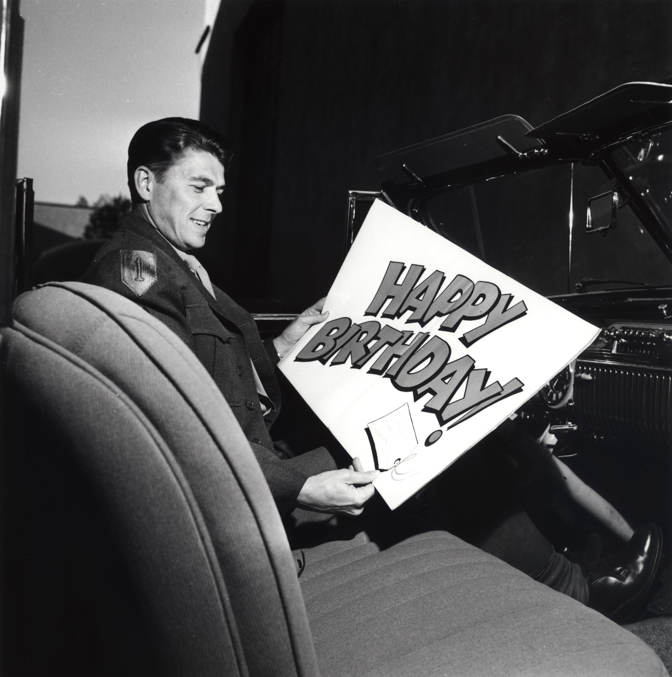 GB6.jpg Ronald Reagan sitting a car with a large birthday card