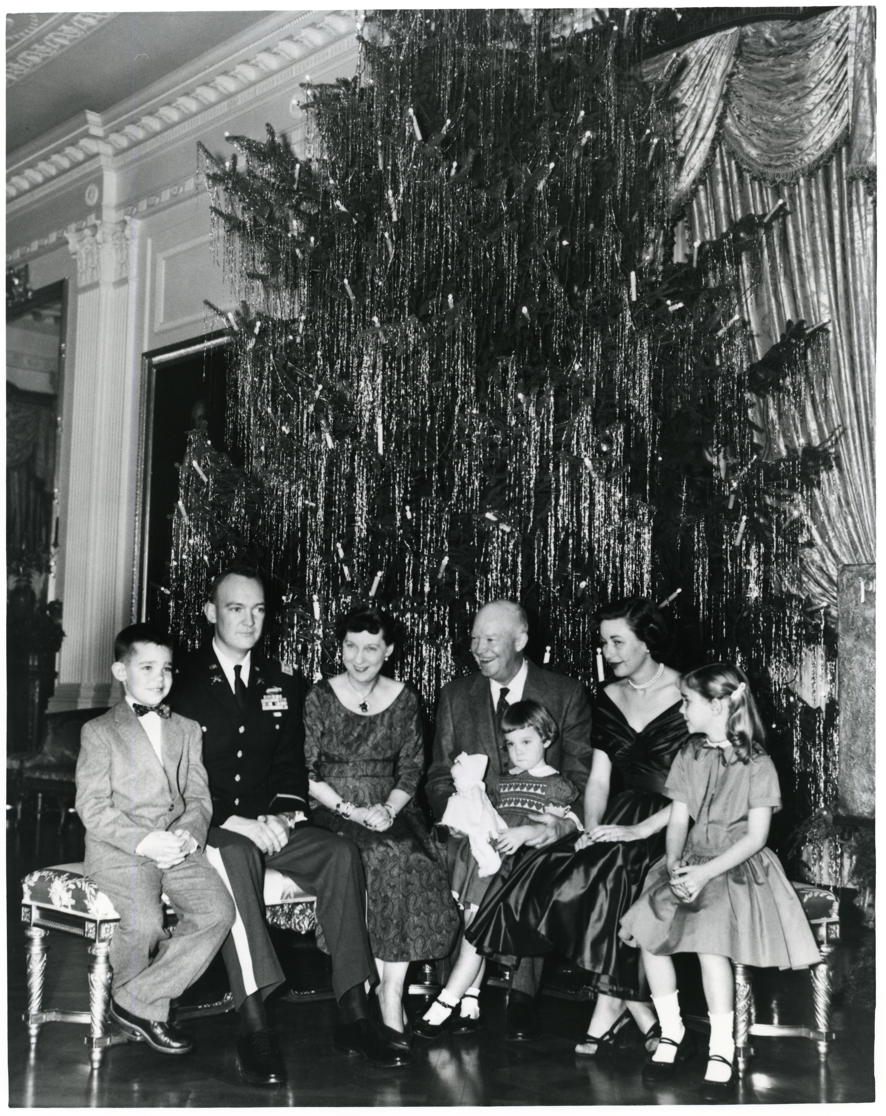 President Eisenhower, Mamie Eisenhower and family sitting next to White House Christmas tree