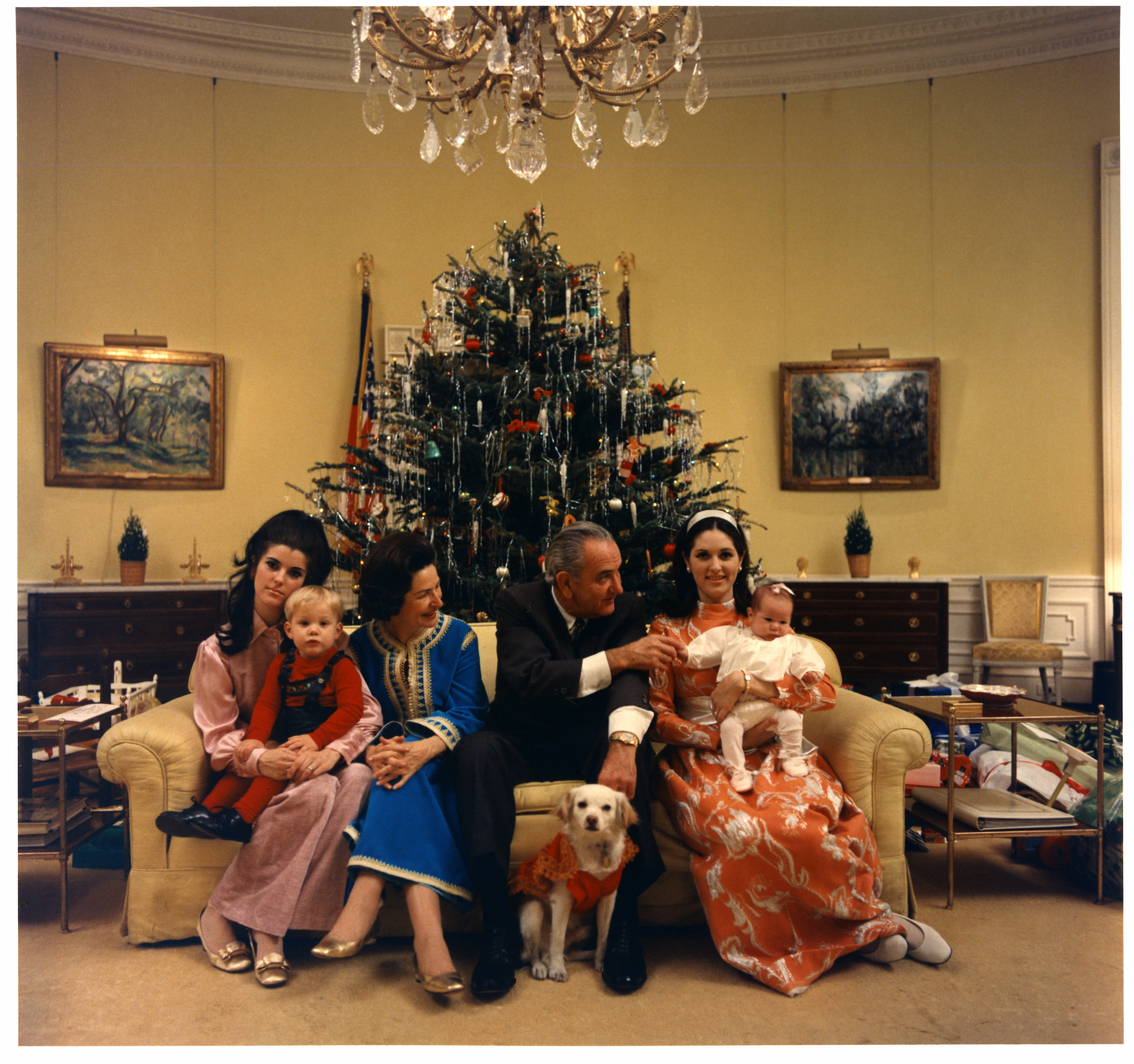 President Johnson and family sitting by the White House Christmas tree in Yellow Oval Room