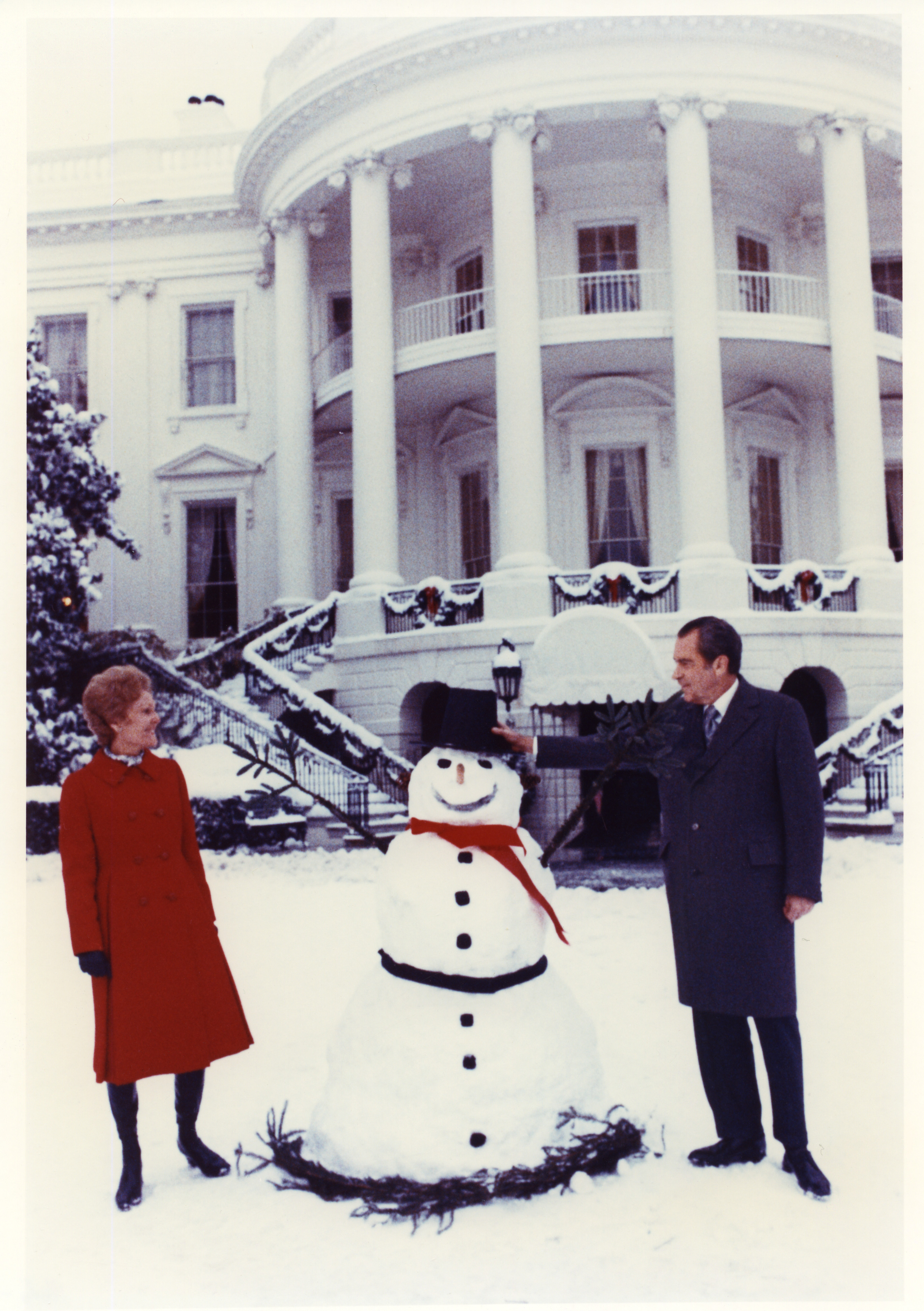 President Nixon and Pat Nixon with snowman on south lawn at the White House