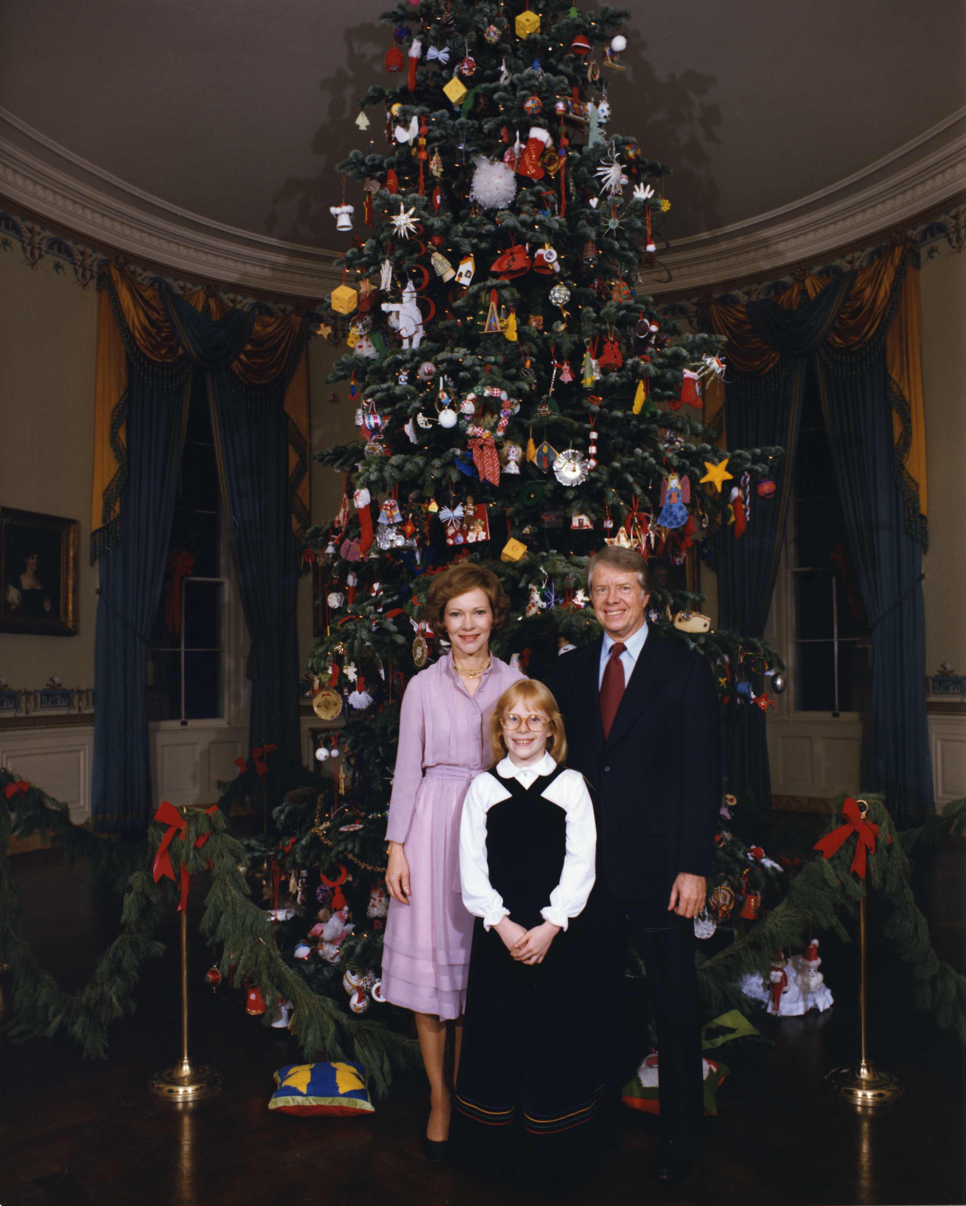 President Jimmy Carter, Rosalynn Carter and Amy Carter standing by White House Christmas tree in Blue Room