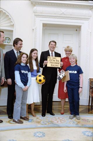 President Reagan holding sign