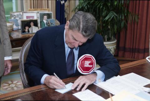6-27-1985 President Reagan standing with a "halt the deficit" button in the oval office