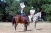 Nancy Reagan holding up “Just Say No” sign for press photographers while horseback riding with President Ronald Reagan at Rancho del Cielo in Santa Barbara, California 09/06/1986  NAID: 75855005