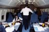 President Ronald Reagan talking with staff aboard Air Force One during return trip to Andrews Air Force Base, 11/21/1985