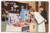 Postcard - Photograph of Nancy Reagan in the White House looking at a display of drugs and anti-drug paraphernalia, back of postcard reads “Warm press comments appeared about Nancy Reagan and her crusade against drugs, as she blossomed as an advocate for more understanding and help in this national problem affecting so many people March 1982, CL-RR #98 SC18231-colorphoto"© John Ficara Woodfin Camp.