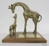 This is a sculpture of two brass giraffes, one large and the other small. The larger giraffe is craning its neck down toward the smaller giraffe, which is looking up toward it. The giraffes are mounted on a wooden base with a brass plaque stating "NANCY REAGAN 'FOR STICKING YOUR NECK OUT FOR KIDS', NATIONAL FEDERATION OF PARENTS FOR DRUG-FREE YOUTH, SEPTEMBER 28, 1984." Nancy Reagan attended the third annual National Federation of Parents NFP luncheon on 09/28/1984.