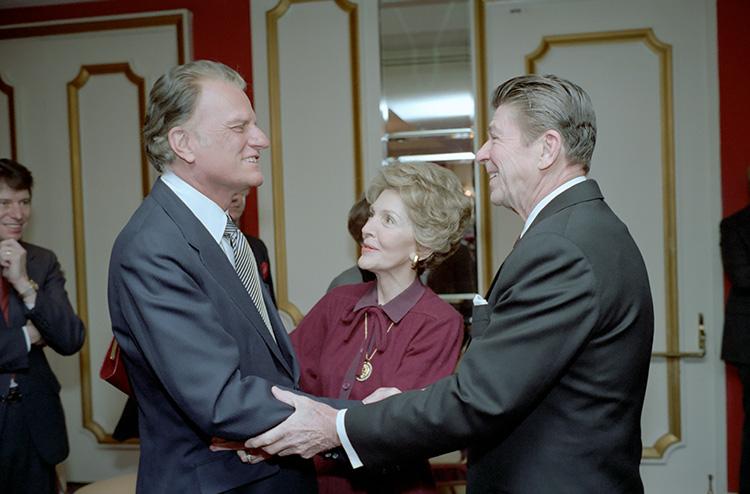 President Ronald Reagan and Nancy Reagan greet evangelist William “Billy” Graham at the National Prayer Breakfast at the Washington Hilton Hotel 02/05/1981 NAID: 75856393