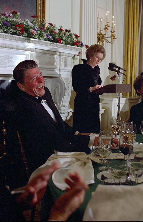 President Ronald Reagan laughing while Prime Minister Margaret Thatcher of the United Kingdom gives a toast during the state dinner in the State Dining Room 02/26/1981NAID: 276563119
