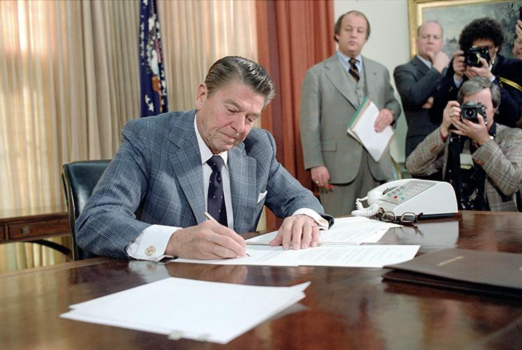 President Ronald Reagan signing a Memorandum Directing Reductions in Federal Spending in the Oval Office 01/22/1981 NAID: 276563073