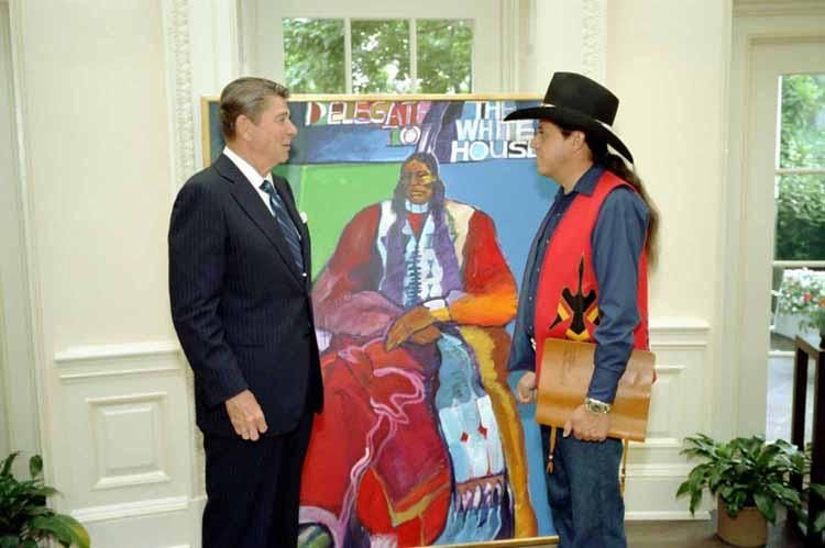 President Ronald Reagan with contemporary artist John Nieto in the Oval Office being presented with the painting Delegate to the White House 08/05/1982  NAID: 75856951