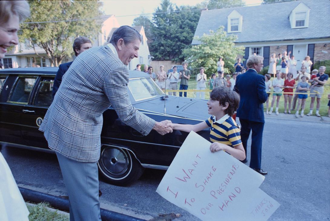 President Ronald Reagan shaking hands with Josh who holds a sign that reads “I want to shake our President’s hand” in Bethesda, Maryland 06/05/1983 NAID: 75852861