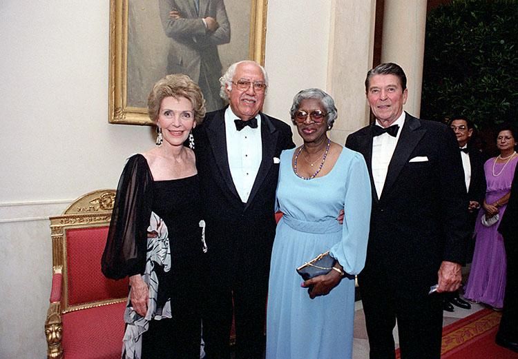 President Ronald Reagan and Nancy Reagan with White House maître d' John Ficklin and Nancy Ficklin in the Cross Hall during a state dinner for the  07/19/1983  NAID: 75852925