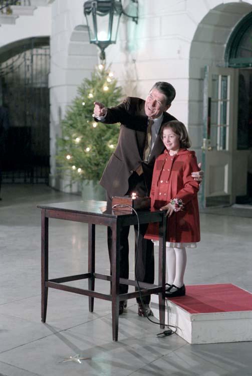 President Ronald Reagan and Amy Benham participating in a ceremony to light the National Christmas Tree on the Ellipse 12/15/1983  NAID: 75853179