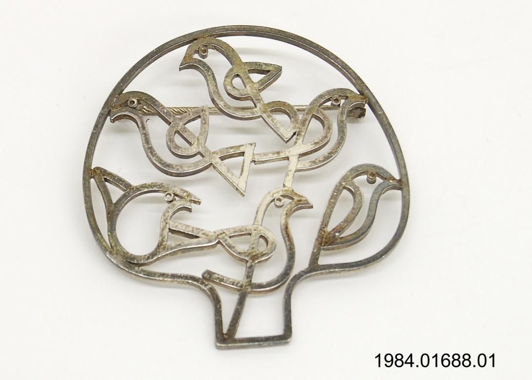 A sterling silver openwork pin depicting partridges in a pear tree, given during a trip to Ireland June 1-4, 1984. Gifter: Joan O’Farrell FitzGerald, wife of Prime Minister Garret FitzGerald of Ireland. Artifact ID: 1984.01688.01 