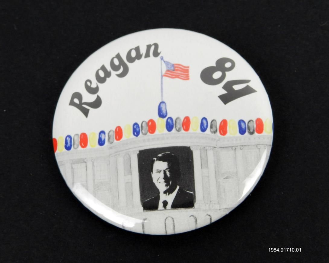 Handmade campaign button with a black-and-white image of President Ronald Reagan in the White House decorated with Jelly Beans and the text "REAGAN 84."