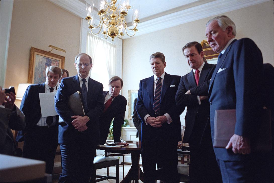 President Ronald Reagan and staff watching televised replay of the Space Shuttle Challenger explosion. Left to right: Larry Speakes, Dennis Thomas, Jim Kuhn, President Ronald Reagan, Pat Buchanan, and Donald Regan 01/28/1986  NAID: 75854569