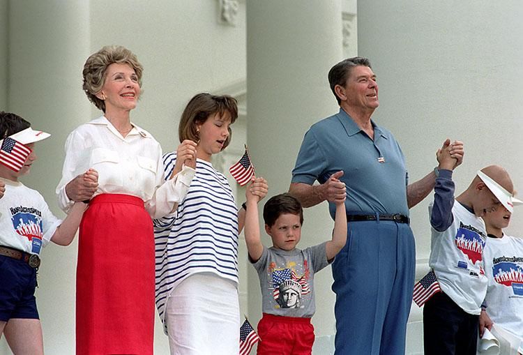 President Ronald Reagan and Nancy Reagan participating in the Hands Across America event at the North Portico 05/25/1986 NAID: 75854809