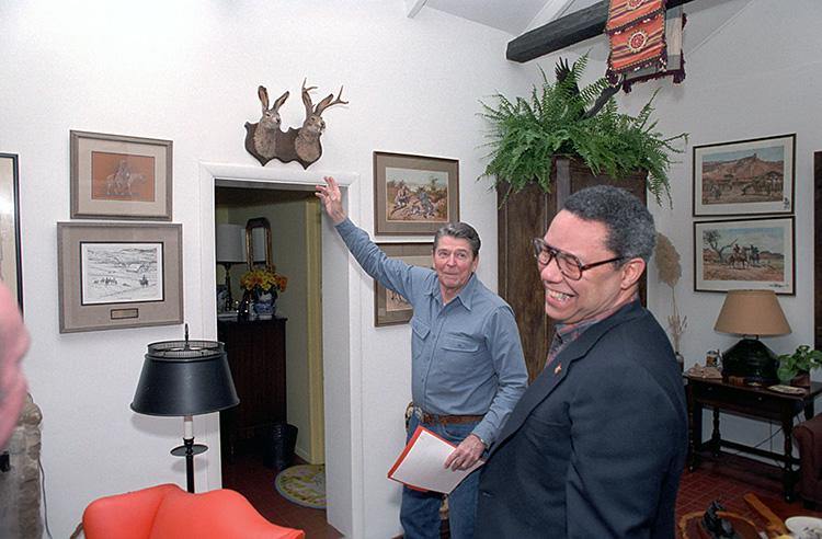 President Ronald Reagan showing National Security Advisor Colin Powell the “jackalope” in the living room inside Ranch del Cielo, Santa Barbara, California 11/25/1987 NAID: 276564597