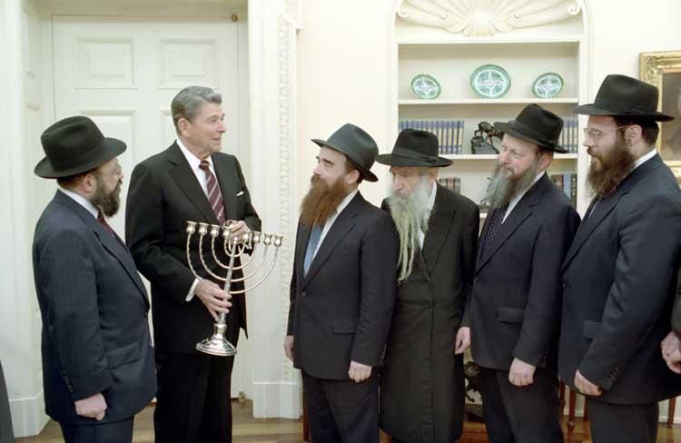 President Ronald Reagan receiving a menorah from the Friends of Lubavitch in the Oval Office 12/15/1987  NAID: 6728689