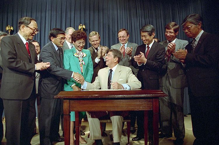 President Ronald Reagan signing the Civil Liberties Act of 1988 in the Old Executive Office Building 08/10/1988  NAID: 276564919