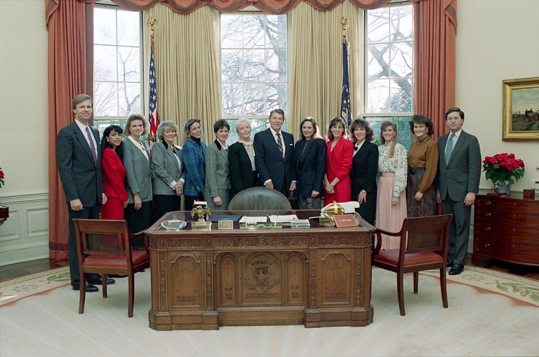 President Ronald Reagan in a photo opportunity with his Century City office staff in the Oval Office Left to right: Fred Ryan, Suzie Talaat, Sherry Seamon, Kathy Osborne, Sandy Warfield, Joanne Hildebrand Drake, Dottie Dellinger, President, Jeanine Chase, Kerry Geoghan, Kerri Douglas, Selina Jackson, Paula Franklin, and Mark Weinberg 12/19/1988  NAID: 404525495