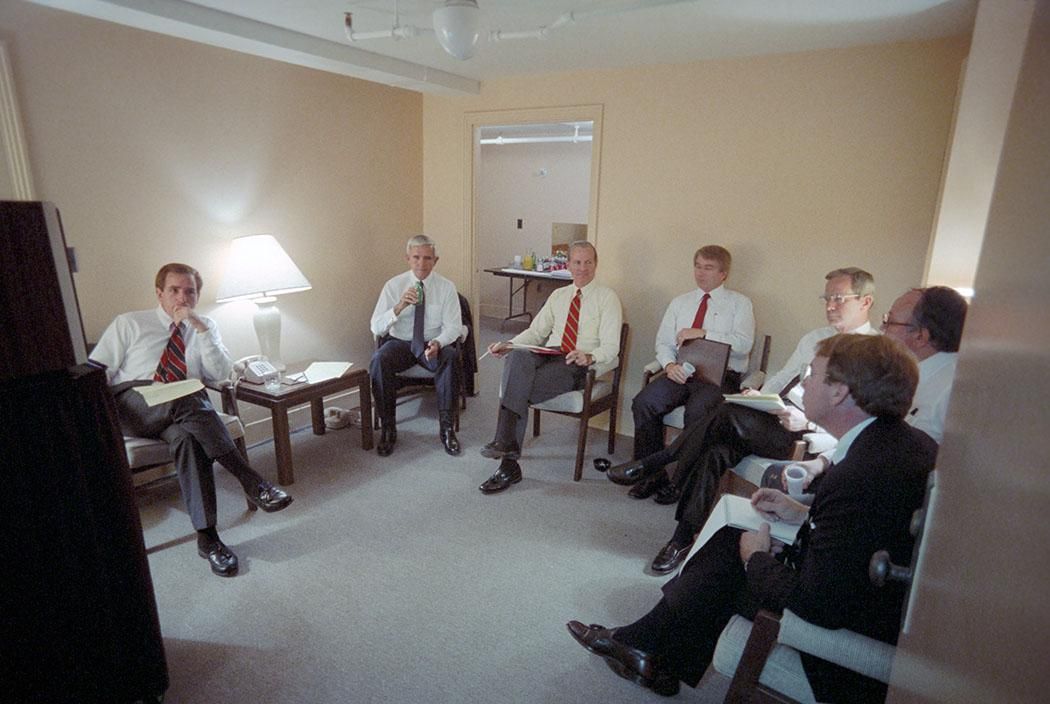 Senior staff watching the second presidential debate on defense and foreign policy with James Baker, Senator Paul Laxalt, Larry Speakes, Richard Darman, Robert McFarlane, and Roger Ailes at the Kansas City Convention Center Holding Room, Kansas City, Missouri 10/21/1984