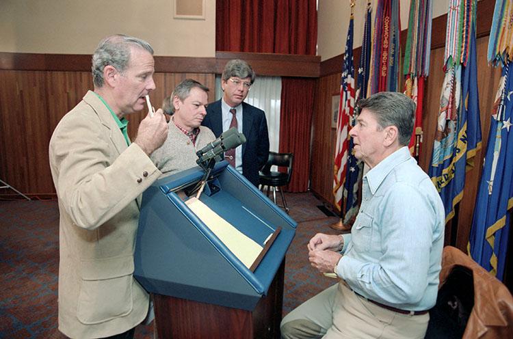 President Ronald Reagan talking with James Baker, John Svahn, and Richard Wirthlin during debate preparation for the upcoming presidential debate on domestic policy in Laurel Lodge at Camp David 10/06/1984
