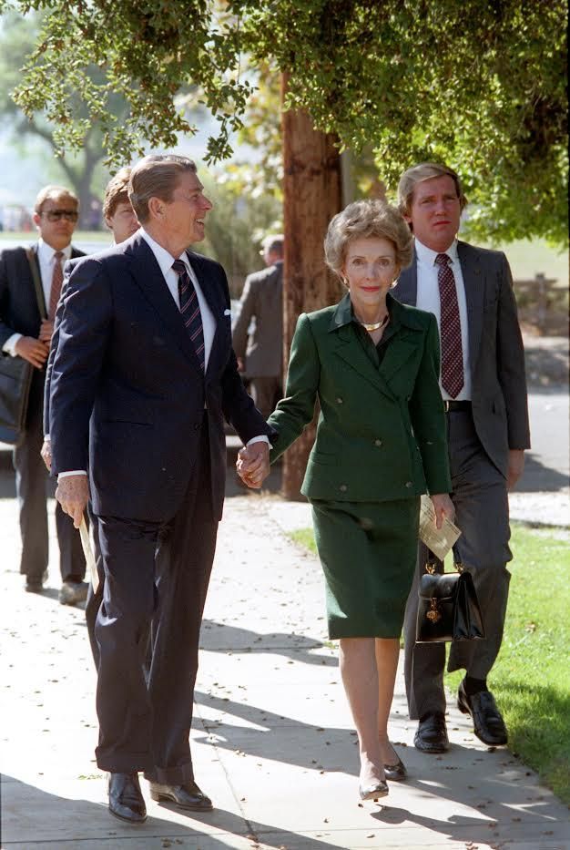 President Ronald Reagan and Nancy Reagan holding hands and walking to turn in their absentee ballots at the Solvang Veterans’ Memorial Building in Solvang, California 11/06/1984 