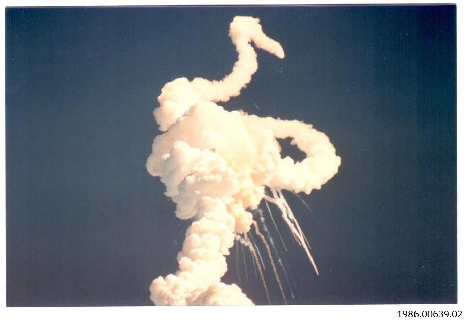 Challenger Shuttle Photograph Artifact ID: 1986.00639.02 Object Name: Photograph Maker: Raymond G. Moore, Torrance, California Date Made: 1986 Description: A color photograph of the Challenger shuttle explosion with smoke and debris in the air. Verso is blank.