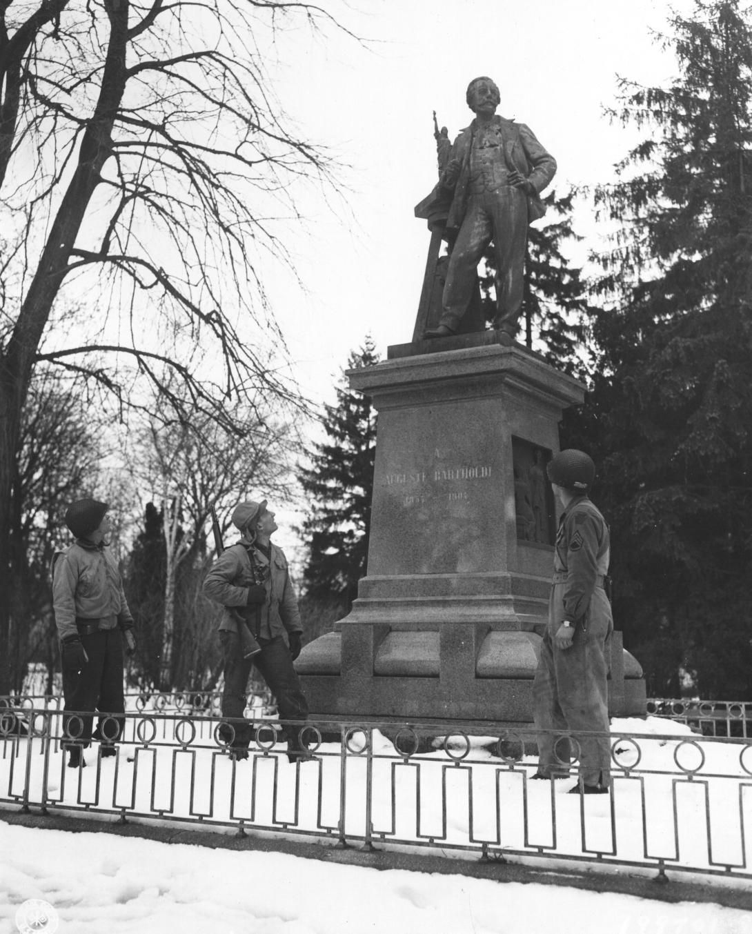 Photograph of Infantrymen at the Bronze Monument to Auguste Bartholdi. Produced: February 3, 1945 Photographs of American Military Activities ca. 1918-ca. 1981. NAID: 6928079