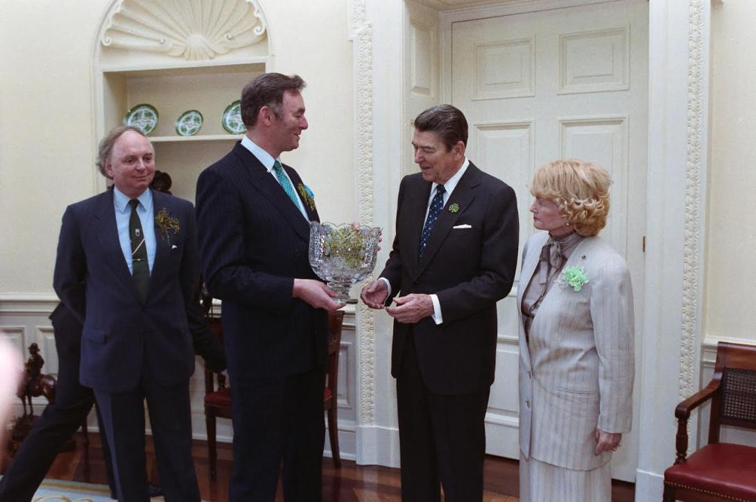 President Ronald Reagan receiving the traditional presentation of shamrocks in the Oval Office with the U.S. Ambassador to Ireland Margaret Heckler,  03/17/1988