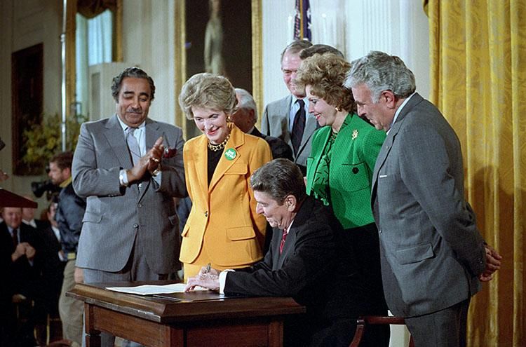 President Ronald Reagan with Nancy Reagan during the signing ceremony for H.R. 5484 – The Ant-Drug Abuse Act of 1986 with Senator Paula Hawkins and Representatives Charles Rangel and Benjamin Gilman in the East Room dated 10/27/1986