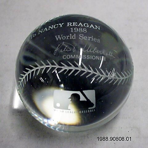 A crystal baseball etched with stitching and MLB logo, lettered “To NANCY REAGAN 1988 World series [signature] Pete V. Ueberroth COMMISSIONER MAJOR LEAGUE BASEBALL.” The ball was given to First Lady Nancy Reagan by Peter Ueberroth, Commissioner, Major League Baseball, during the opening of the 1988 World Series, held in Los Angeles, California. Nancy Reagan threw out the first pitch of Game One on 10/15/1988. That year, Los Angeles Dodgers defeated the Oakland Athletics 4 games to 1.